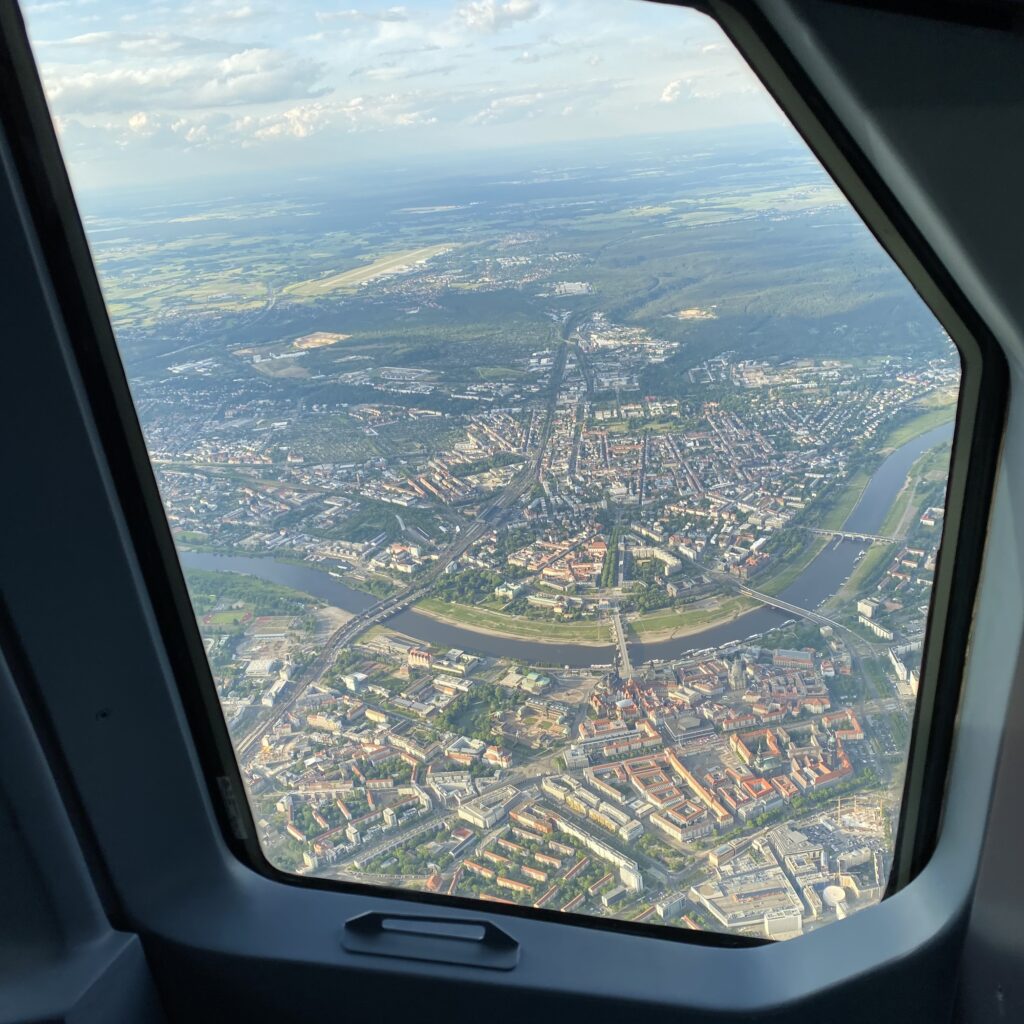 Blick durch das Cockpitfenster auf eine Stadt